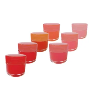 多色小圓罐變色護唇膏排成一列展示，透明底座搭配紅色、橘色與粉色膏體與瓶蓋。Row of color-changing lip balm pots with clear bases and red, orange, and pink shades on a white background.